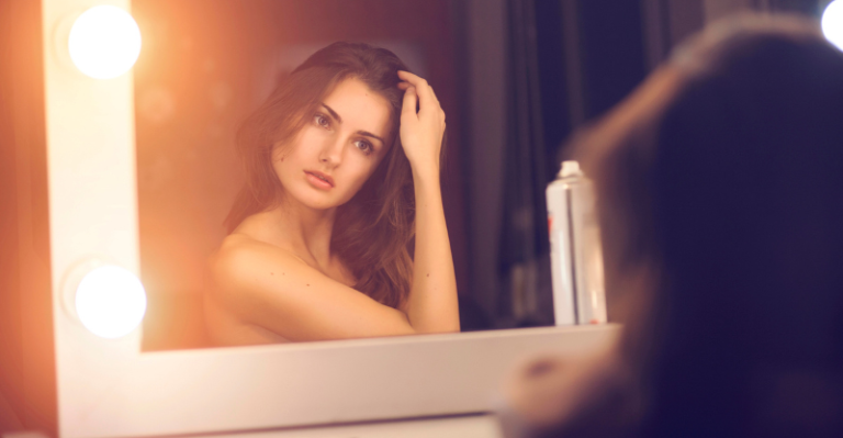 woman looking into mirror
